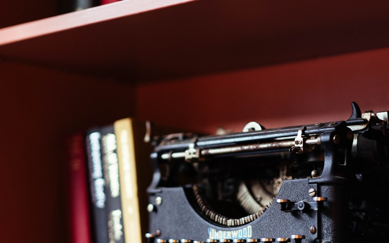 Vintage typewriter on a shelf with books